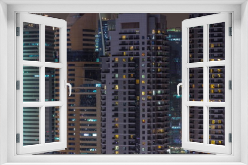 Fototapeta Naklejka Na Ścianę Okno 3D - Residential and office buildings in Jumeirah Lake Towers aerial night timelapse in Dubai, UAE.