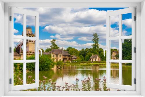 Fototapeta Naklejka Na Ścianę Okno 3D - Beautiful panoramic landscape view of the Marlborough Tower, the Queen’s House, the boudoir and the mill from the lake in the Queen’s Hamlet at the Petit Trianon park of Versailles on a summer day.