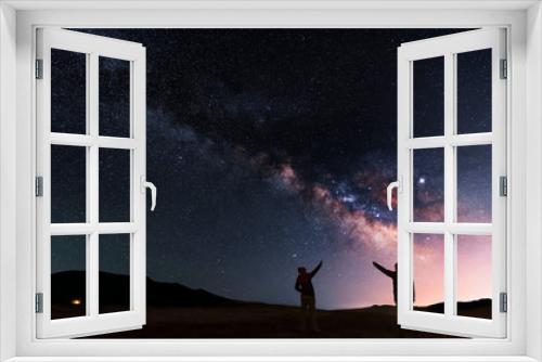 Fototapeta Naklejka Na Ścianę Okno 3D - Beautiful night landscape. Two silhouettes stand on a hill and look at the bright galaxy Milky Way