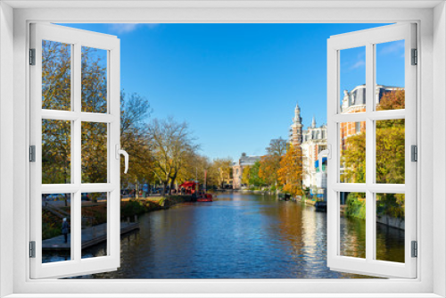 Fototapeta Naklejka Na Ścianę Okno 3D - House and boat reflections in the canals of Amsterdam, autumn colors and blue sky