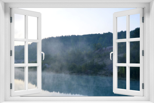 Fototapeta Naklejka Na Ścianę Okno 3D - Morning mood with sunrise with a haze over a lake in the mountains. That artificial lake formed after the extraction of chalk in an industrial quarry at Krasnoselsky village in the Belarus.