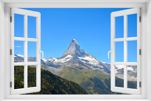 Fototapeta Naklejka Na Ścianę Okno 3D - Gorgeous Matterhorn with a green and orange forest and a clear blue sky, Zermatt, Switzerland