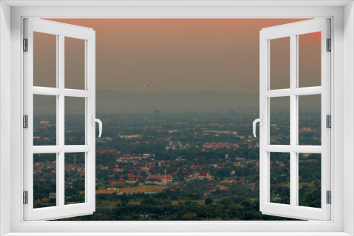 Fototapeta Naklejka Na Ścianę Okno 3D - Blurry high angle nature background, which can see distant views (houses, mountains, trees, roads). The atmosphere is surrounded by the wind blowing through, seen at the natural viewpoint on the way.