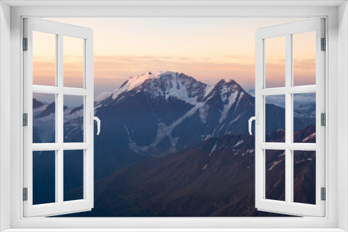 Fototapeta Naklejka Na Ścianę Okno 3D - beautiful sunrise in the mountains. Golden hour photography, the rising sun behind the mountains. Yellow and pink color. Mount Elbrus. Russia. The Caucasus. Panorama of mountains at sunrise.