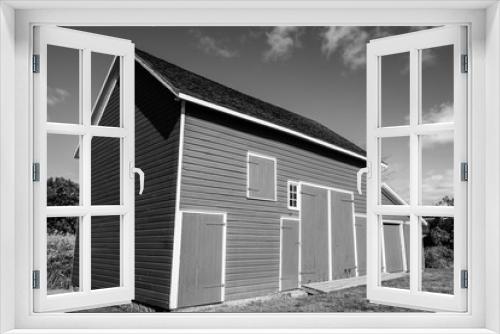 Fototapeta Naklejka Na Ścianę Okno 3D - Isolated red barn in wooded area. Red farm barn building exterior. 