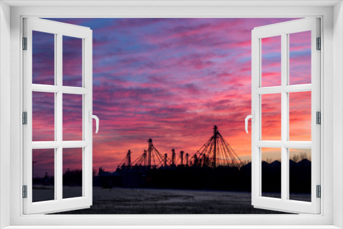 Fototapeta Naklejka Na Ścianę Okno 3D - Industrial Facility Silhouetted Against Fiery Red Sunset