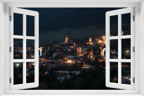 Fototapeta Naklejka Na Ścianę Okno 3D - Night view on Mestia with its beautiful illuminated Svan Towers and high mountains. Svaneti, Georgia.