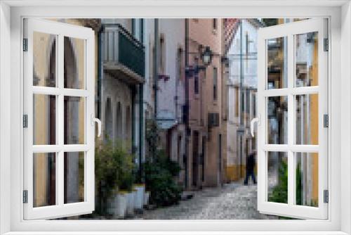 Fototapeta Naklejka Na Ścianę Okno 3D - Cobblestone alley winding through traditional Portuguese old town buildings