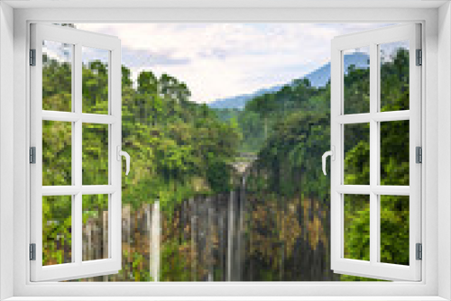 Fototapeta Naklejka Na Ścianę Okno 3D - View from above, stunning aerial view of the Tumpak Sewu Waterfalls also known as Coban Sewu with clouds raising from the canyon. Semeru volcano in the distance, Malang Regency,East Java, Indonesia.