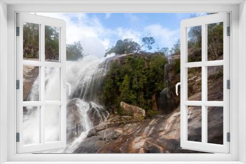 Fototapeta Naklejka Na Ścianę Okno 3D - Waterfall with a strong flood of water rocks below. Crystal clear water, huge stones with a beautiful vegetation around.At the end forming a strong current and later a calm lake with clean transparent