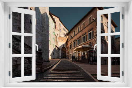 Fototapeta Naklejka Na Ścianę Okno 3D - The streets of the old city are flooded with sun. Stairs of the old city of Perugia. Umbria Italy.