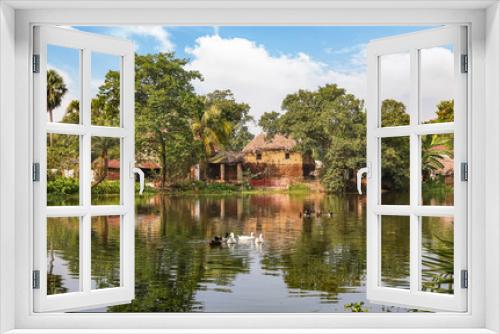 Fototapeta Naklejka Na Ścianę Okno 3D - Village pond with view mud hut and ducks swimming in the water at Bolpur district of West Bengal, India
