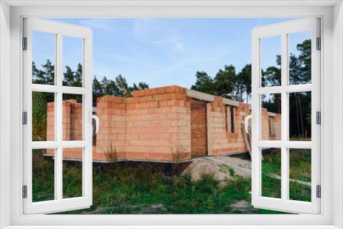 Fototapeta Naklejka Na Ścianę Okno 3D - Exterior of a Unfinished Red Brick House Walls under Construction without Roofing