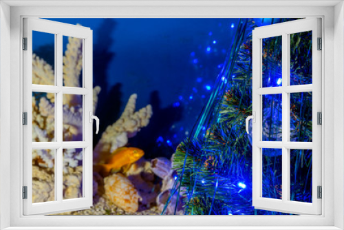 Fototapeta Naklejka Na Ścianę Okno 3D - Christmas tree with decorations and a garland and an aquarium in the background