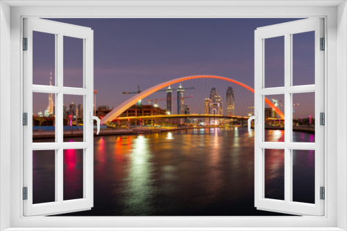 Fototapeta Naklejka Na Ścianę Okno 3D - Panoramic night view on Dubai at blue hour, showing Bridge of tolerance and iconic buildings and construction cranes