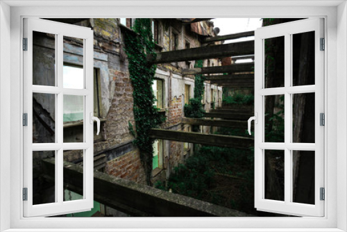 Fototapeta Naklejka Na Ścianę Okno 3D - Inside ruined building overgrown by plants. Nature and abandoned architecture, green post-apocalyptic concept