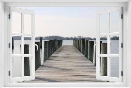 Fototapeta Naklejka Na Ścianę Okno 3D - Old weathered wooden dock on a sandy coastal