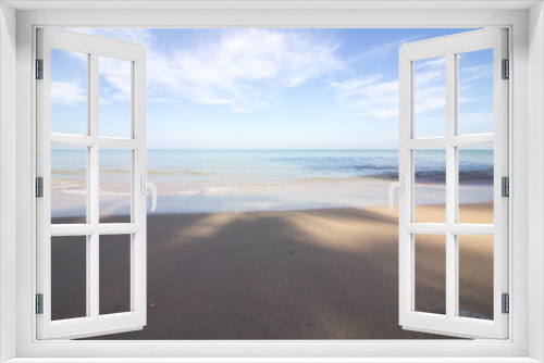 Fototapeta Naklejka Na Ścianę Okno 3D - Das rugige Meer an einem wunderschönen Sandstrand verschwimmt mit dem blauen Himmel