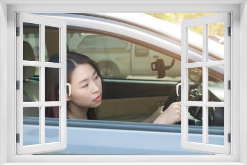 Young Asian woman is looking at front while driving traffic jammed.