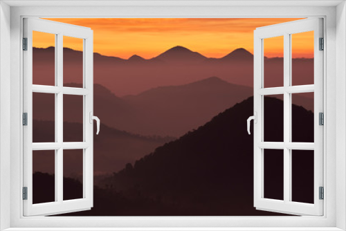 Fototapeta Naklejka Na Ścianę Okno 3D - Sunrise with silhouette of mountains under orange sky