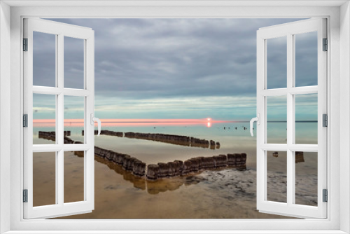 Fototapeta Naklejka Na Ścianę Okno 3D - Old wooden pool in front of Sunset clouds reflected in the smooth water of the salt lake