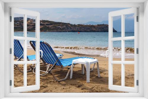 Fototapeta Naklejka Na Ścianę Okno 3D - two sun loungers on the sandy beach of the Greek resort town of Agios Nikolaos