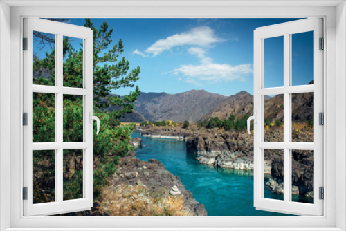 Fototapeta Naklejka Na Ścianę Okno 3D - Turquoise Katun river in a deep rocky gorge surrounded by high mountains under blue sky on sunny autumn day. Green coniferous trees grow on the stony banks of Siberian river.