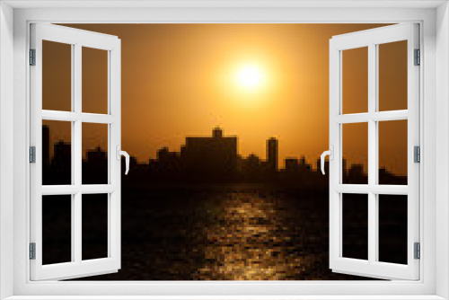 Fototapeta Naklejka Na Ścianę Okno 3D - The sun setting over Havana with a silhouetted view of the city