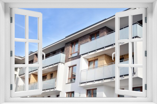 Fototapeta Naklejka Na Ścianę Okno 3D - Modern apartment buildings on a sunny day with a blue sky. Facade of a modern apartment building.Glass surface with sunlight.