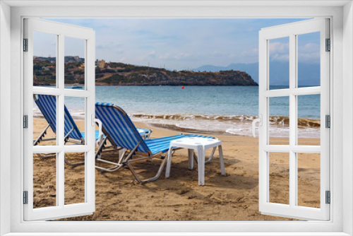 Fototapeta Naklejka Na Ścianę Okno 3D - two sun loungers on the sandy beach of the Greek resort town of Agios Nikolaos
