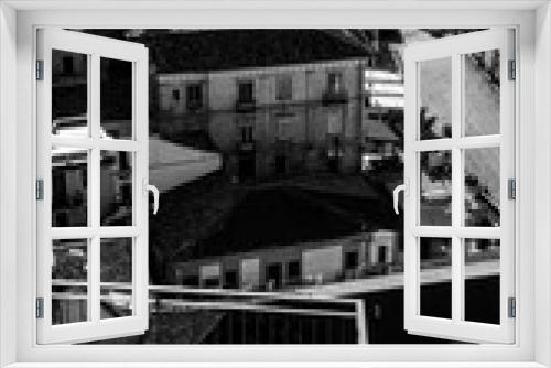 Fototapeta Naklejka Na Ścianę Okno 3D - Coast of Calabria, Italy: view in black and white of the Marina beach in Pizzo Calabro on a winter day. Skyline of the town seen from a panoramic point, a belvedere called U Spunduni (The Balcony)
