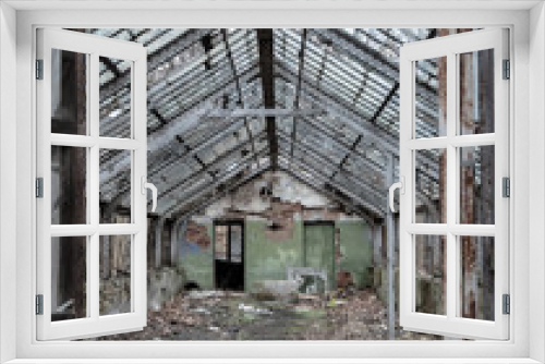 Fototapeta Naklejka Na Ścianę Okno 3D - Dilapidated abandoned greenhouse in a city forest park