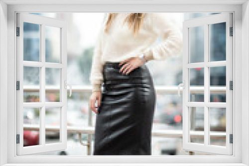 Beautiful woman in leather skirt posing on the street