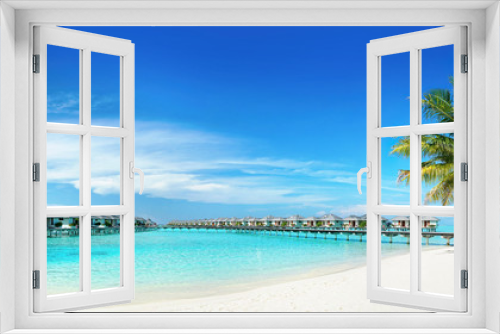 Fototapeta Naklejka Na Ścianę Okno 3D - Coconut Palm tree on amazing perfect white sandy beach in island of Maldives panoramic view. Water bungalows in ocean against blue sky with clouds. Nature summer vacation background, copy space.