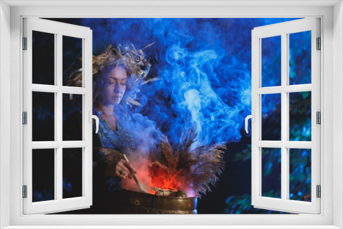 Fototapeta Naklejka Na Ścianę Okno 3D - A forest witch brews a potion holding a Voodoo doll.