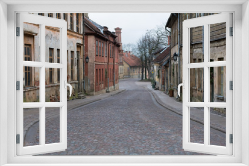 Fototapeta Naklejka Na Ścianę Okno 3D - Old city street with old stone and wooden facades and stone paving road