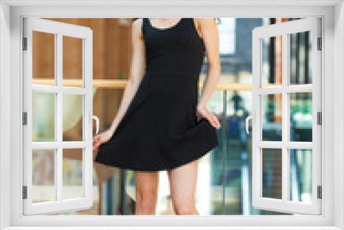 Full body portrait of a happy young brunette woman in black dress