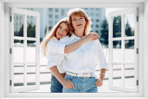 Elegant mother with young daughter. Family in a park. Women in a white shirts