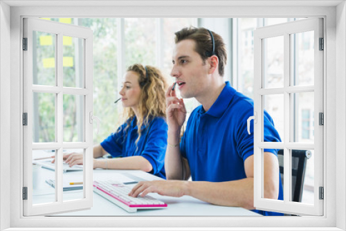 Customer support operator at work. Team Business and Delivery call center in office. Working with a headset in blue uniform.