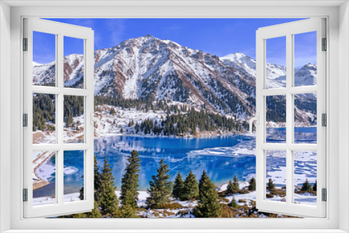 Fototapeta Naklejka Na Ścianę Okno 3D - Autumn gives way to winter, air temperature drops and the water in the lake begins to freeze. Texture and patterns of ice on the serene water surface of a mountain lake; Big Almaty lake in Kazakhstan