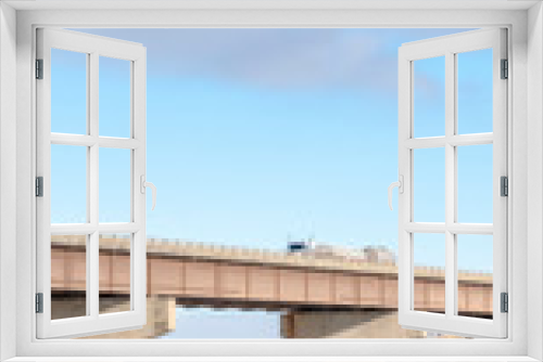 Fototapeta Naklejka Na Ścianę Okno 3D - Vertical frame Stringer bridge supported by abutments ovelooking lake land and cloudy sky
