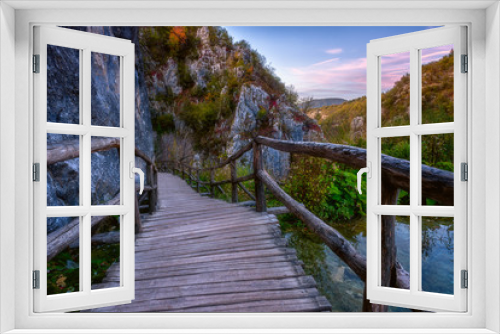 Fototapeta Naklejka Na Ścianę Okno 3D - Plitvice lakes (Plitvicka jezera) national park, Croatia. Amazing sunset landscape with tourist route on the wooden flooring along the cliff and lake. Travel background, famous landmark
