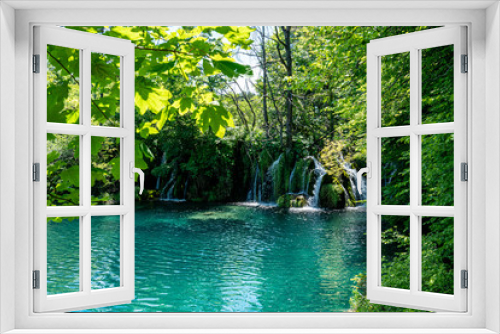 Fototapeta Naklejka Na Ścianę Okno 3D - See mit Wasserfall im Wald in Vordergrund Zweige und Blätter Plitvicer Seen