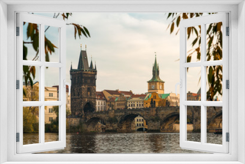 Fototapeta Naklejka Na Ścianę Okno 3D - View of the Charles Bridge Through Autumn Leaves in Prague, Czechia