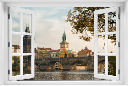 Fototapeta Naklejka Na Ścianę Okno 3D - View of the Charles Bridge Through Autumn Leaves in Prague, Czechia