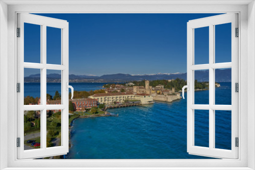 Fototapeta Naklejka Na Ścianę Okno 3D - Unique view. Aerial photography, the city of Sirmione on Lake Garda north of Italy. In the background is the Alps in the snow. Resort place. Aerial view. Autumn-winter season