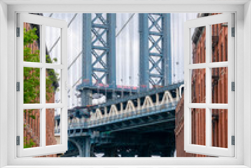 Fototapeta Naklejka Na Ścianę Okno 3D - View of the famous Manhattan Bridge, with the Empire State Building in the background, located in the neighborhood of Brooklyn, New York, USA