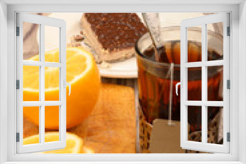 Fototapeta Naklejka Na Ścianę Okno 3D - Tea in a faceted glass in a vintage Cup holder, sliced lemon on a Board and a piece of waffle cake on a white plate on a wooden background. Close up.
