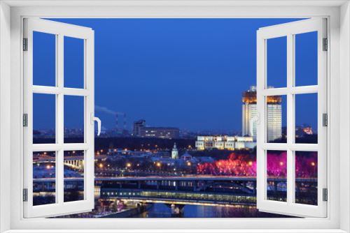 Fototapeta Naklejka Na Ścianę Okno 3D - Moscow / Russia – 03 07 2019: House of Presidium of the Academy of Sciences, Moscow river with Metro bridge and red illuminated trees at winter night, view from Vorobyovy Hill Observation deck