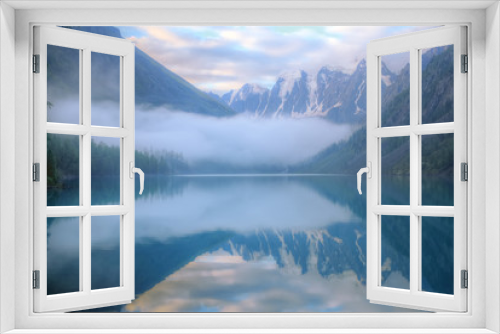 Fototapeta Naklejka Na Ścianę Okno 3D - Misty morning on a mountain lake. High mountains with glacier, cold lake and fog. Thick fog swirls over the water.